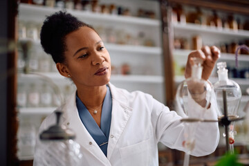 Smiling black chemist working in a pharmacy.