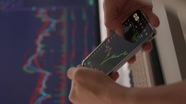 Trader observes price fluctuations closely, Hands manipulate trading charts intensely during session, Trader focuses on chart patterns and volume data to make informed choices