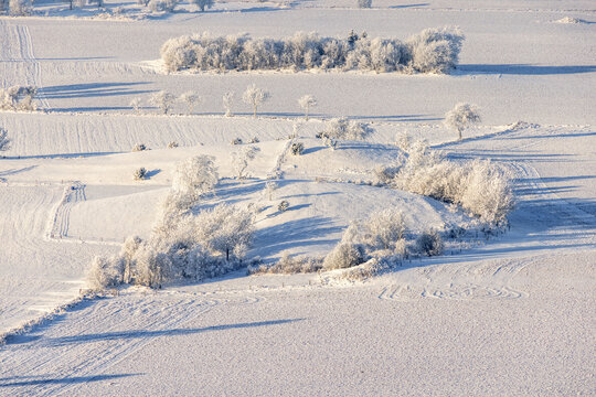 Aerial view at a rural landscape with frost and snow on a hill - Powered by Adobe