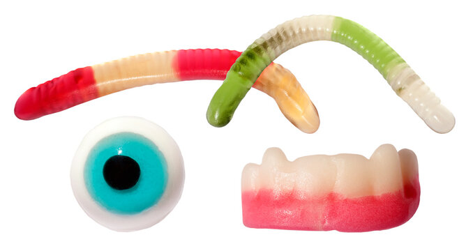 spooky novelty gummy candies featuring brightly colored wiggly worms, a blue eyeball, and frightening vampire teeth, isolated against a dark transparent background. - Powered by Adobe