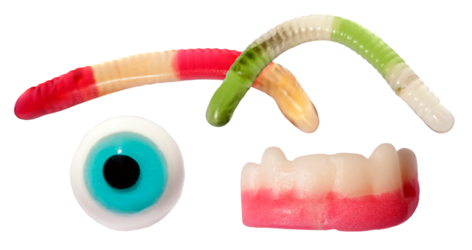 spooky novelty gummy candies featuring brightly colored wiggly worms, a blue eyeball, and frightening vampire teeth, isolated against a dark transparent background.