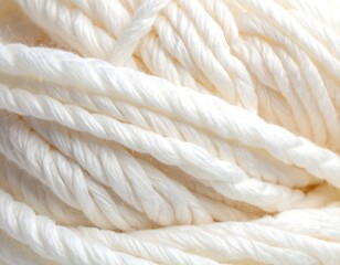 Close-up of a tightly wound ball of thick, white, twisted yarn