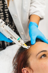 Woman undergoing biostimulation treatment with platelet rich plasma injections to stimulate hair growth and strengthen follicles