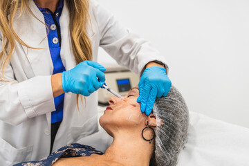 Woman undergoing facial injection procedure, stimulating collagen and elastin production for skin rejuvenation and anti aging results