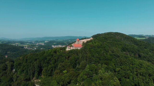 Aerial drone approaches St. Bartholomew Church atop Dilsberg hill, revealing the green valley near Heidelberg, Germany.