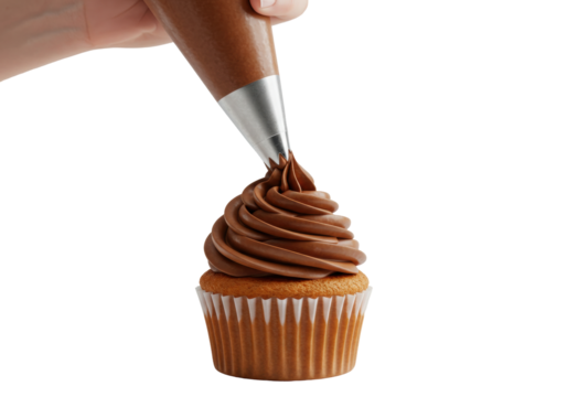 Isolated hand piping rich chocolate frosting onto a delicious vanilla cupcake creating a sweet dessert treat for celebration baking and confectionery art