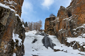 frozen Jermuk waterfall and red rocks of Arpa river canyon (Vayots Dzor, Armenia)