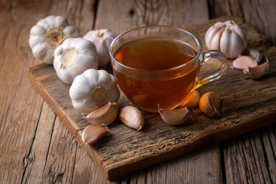 Cup of healthy garlic tea on white background