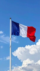 A French tricolor flag waving in the wind against a blue sky with fluffy clouds