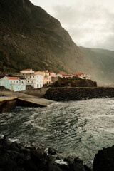 Fototapeta premium Rugged shoreline settlement under dynamic sky with rocky