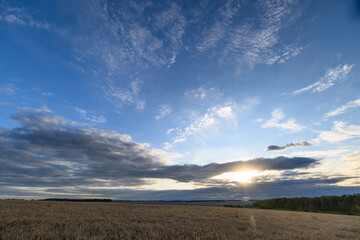 A Stunning Sunset That Beautifully Paints the Sky Over a Serene, Expansive Field at Dusk