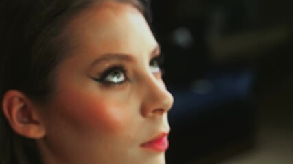 Close up of a stunning model with striking eyes during a makeup session, capturing the gentle process of beauty enhancement and transformation