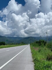 long road on sunshine and cloudy sky background