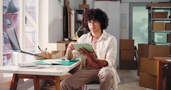 Logistics, scroll and tablet with man in office for delivery, distribution or shipping of boxes. App, planning and reading with employee in supply chain depot for agenda, package tracking or schedule