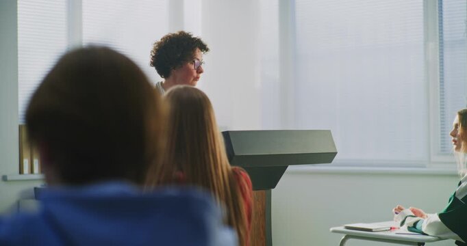 Confident Female Educator Leads Classroom Discussion With Enthusiasm and Empathy. Concept Innovative American Teaching Style, Student Participation, and Collaborative Learning Environment. Dolly Shot.