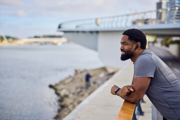African American Man Pondering Weight Loss Goals While Relaxing by Waterfront