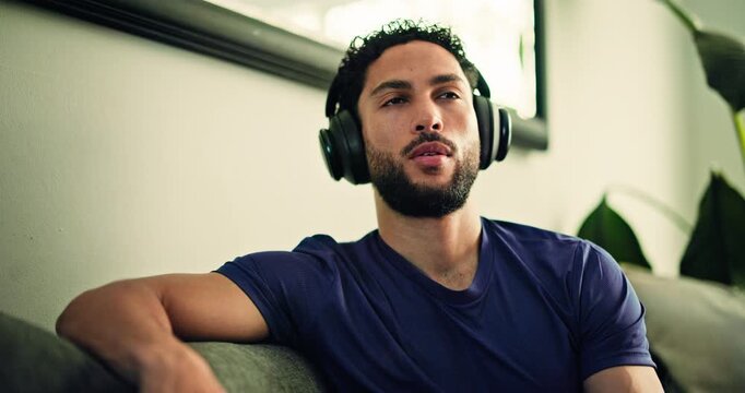 Calm, headphones and man on sofa in home listening to music for relax, peace or mindfulness. Thinking, audio tech and male person chilling in living room with album, radio or playlist at apartment.