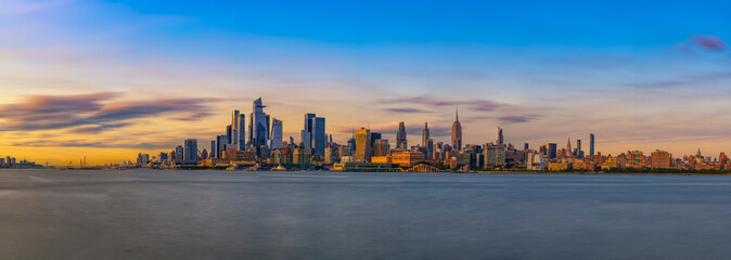 Panorama of New York City Skyline with Hudson Yards District and the Empire State Building at Sunset, seen across the Hudson River.