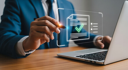 Businessman using a stylus pen interacting with a digital document icon with a check mark representing document approval and quality control on a laptop.