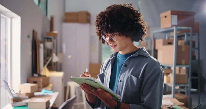 Logistics, tablet and writing with man in office for delivery, distribution or shipping of boxes. App, pen and planning with employee in supply chain depot for agenda, package tracking or schedule