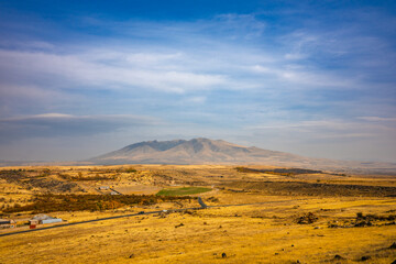 A large mountain is in the background of a dry, barren landscape
