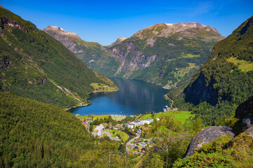 Geirangerfjord with the village of Geiranger nestled among steep green mountains in Norway