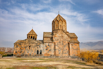 An Armenian Hovhannavank monastery church with a steeple and a small building next to it