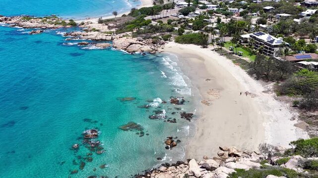 Beautiful aerial footage showcasing the turquoise waters and rocky shoreline of Rose Bay in Bowen. Clear shallows reveal reef textures as the camera glides along the coast, capturing the colours.