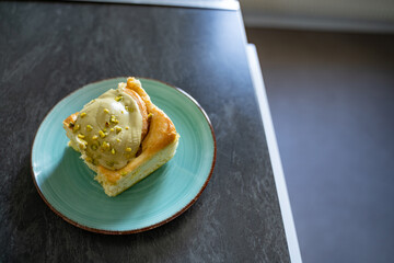 Pistachio cinnamon roll on an artisan plate in a home kitchen, top view. Natural light, simple homemade food setup. Concept of breakfast, pastry, comfort, homemade.