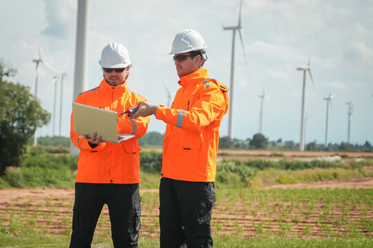 Wind energy workers collaborate on site renewable energy project wind farm outdoor close-up professionalism and safety