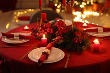 Stylish Christmas table setting with plates, festive decor and burning candles indoors, closeup