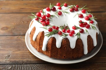 Tasty Christmas cake with cranberries on wooden table, closeup