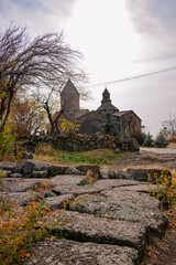 A old grave slabs with a An Armenian Saghmosavanq monastery church in the background