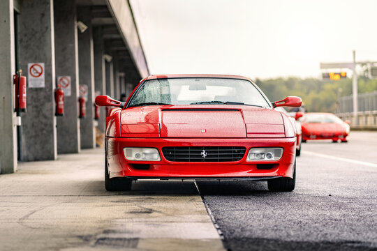 Brno, Czech Republic - October 10, 2025: Red sports car Ferrari 512 TR Testarossa at the pits on the racing circuit. Old rare Italian fast car. Front view.
