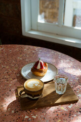 Hot coffee latte with latte art milk foam in cup mug and Homemade Fresh Strawberry and Cream Croissant on marble floor desk on top view. As breakfast In a coffee shop at the cafe,during business work.
