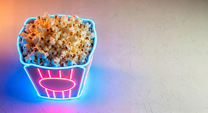 Retro cinema concept — popcorn displayed in glowing neon container, movie snack, entertainment theme backdrop