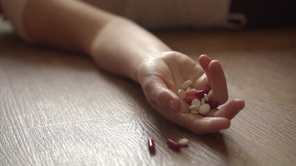 A hand with pills falling to the floor - Powered by Adobe