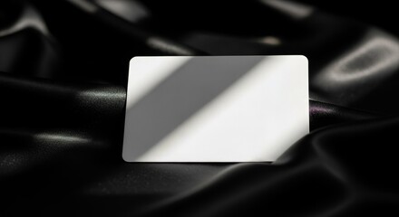 Elegant White Card Mockup on Luxurious Black Silk Fabric.