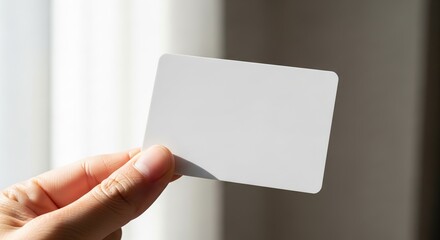 Hand holding a blank white card for mockup.