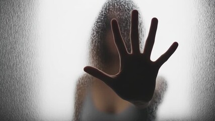 Person silhouette hand pressed against textured glass concept of isolation privacy or barrier - Powered by Adobe