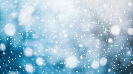Soft snowflakes fall gently against a serene blue background creating a tranquil winter atmosphere perfect for holiday and seasonal themes