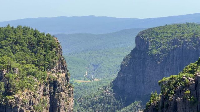 A mountain valley landscape with forests and cliffs. Huge rocks and rocky outcrops. A beautiful deep canyon with lots of tourists. A bird's-eye view of the Tasi Canyon. T&uuml;rkiye