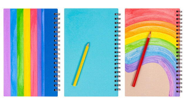 Three spiral notebooks with colorful covers & pencils, arranged in a row