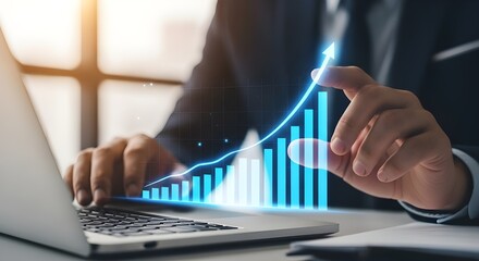 Businessman analyzing financial growth chart on laptop with glowing blue bars and line graph