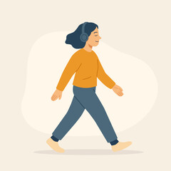 Young woman walking with headphones, listening to music and enjoying peaceful outdoor moment. Concept of mindfulness and slow life.