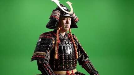 Intense samurai warrior in traditional armor meditating on green screen, embodying strength and focus, perfect for historical dramas or cultural documentaries