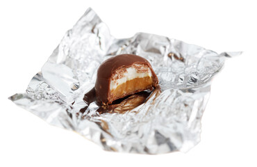 A piece of chocolate cake is sitting on a piece of foil