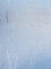 Frozen water drops on glass as an abstract background.