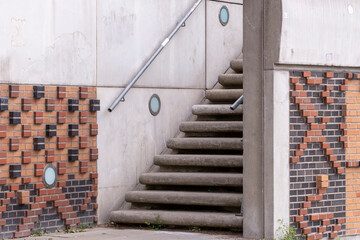 Aligned warehouse heritage facades along a canal in the Speicherstadt district of Hamburg, where the waterway reflects brick facades, a bridge and the maritime urban district