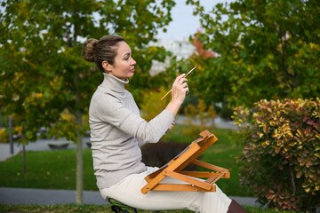 Woman painting outdoors in a park.